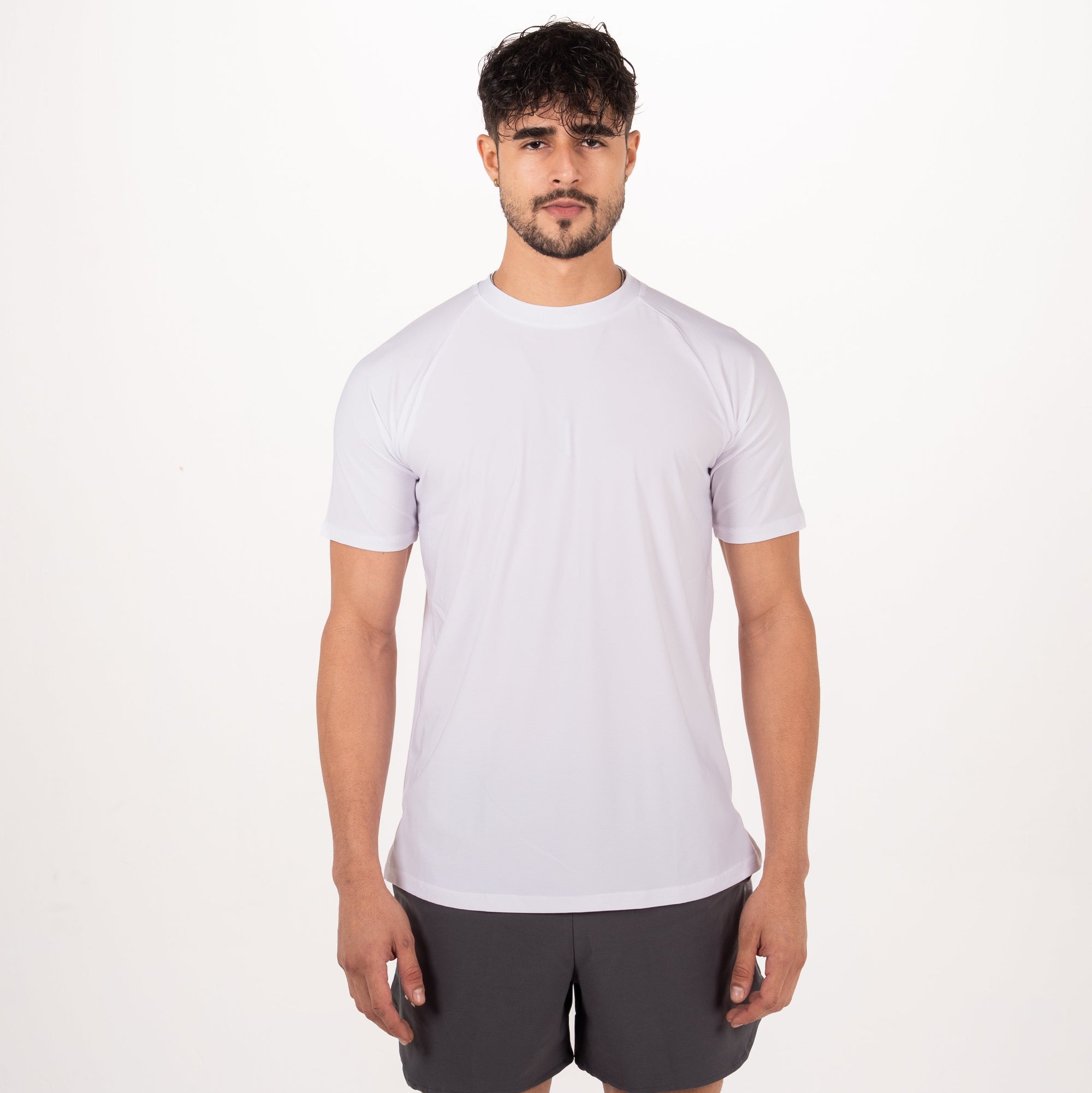 Man wearing a white t-shirt and gray shorts on a white background